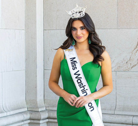 창가 옆에 팔을 교차한 채 서 있는 여성